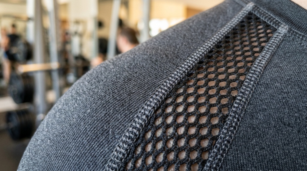 Close-up of moisture-wicking odor-resistant gym wear fabric texture showing mesh ventilation panel