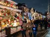 Families walking past elaborately decorated houses covered in Christmas lights and animated figures on 84th Street in Dyker Heights, Brooklyn, in December 2026