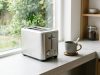 Stainless steel slim toaster on a narrow kitchen counter.
