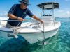 Captain dropping boat anchor in clear Florida coastal waters.